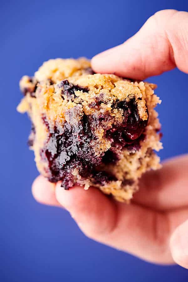 part of blueberry muffin held blue background