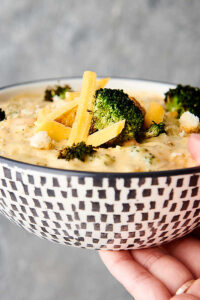 bowl of broccoli cheddar soup held