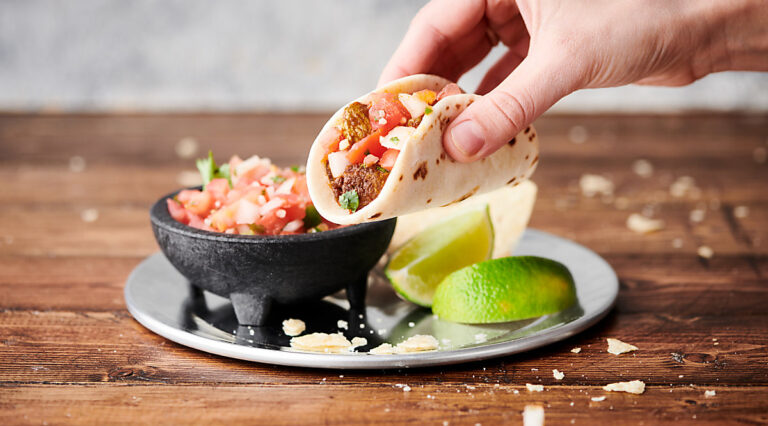 chicken taco being lifted off plate