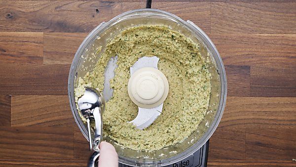 falafel mixture being scooped with cookie scoop