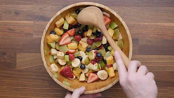 finished fruit salad being scooped with ladle