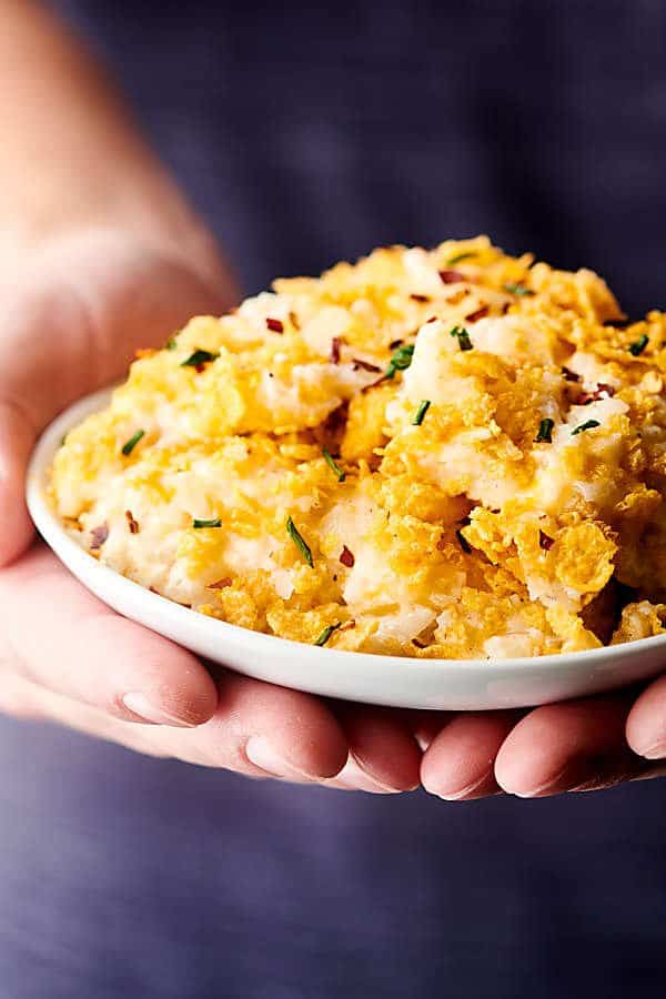 plate of hashbrown casserole held two hands