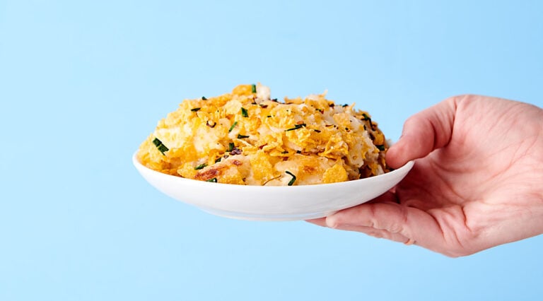 plate of hashbrown casserole held blue background