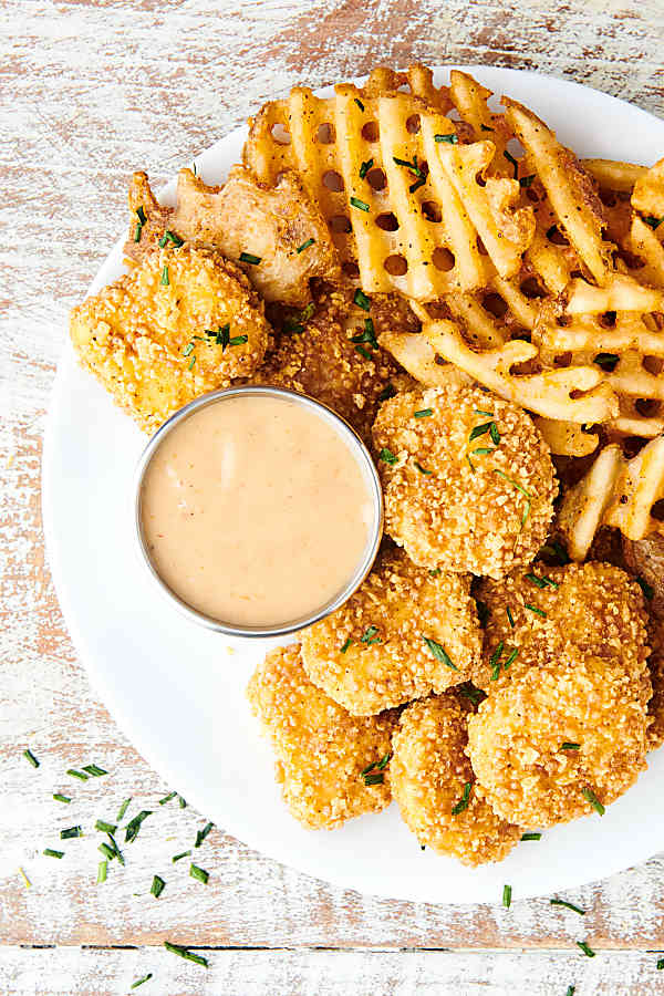 chick fil a sauce on plate with chicken nuggets and waffle fries above