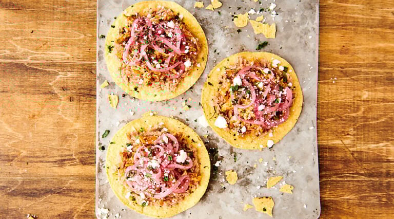 tostadas with chicken tinga on baking sheet above