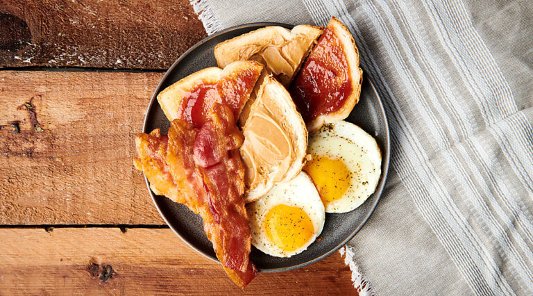 bacon on plate with eggs and toast above