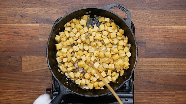 onion and potatoes being cooked in skillet