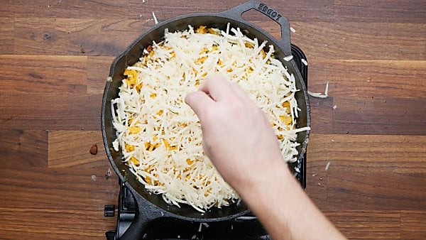 cheese being sprinkled over veggies