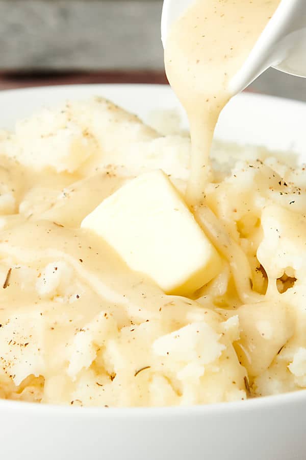 gravy being drizzled over mashed potatoes