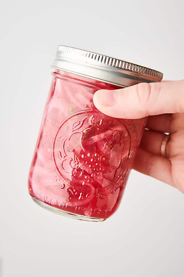 jar of pickled red onions held