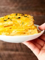 scalloped potatoes on plate held