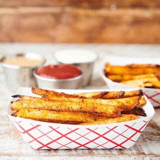 two dishes of air fryer french fries with ketchup and mustard