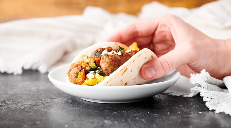 breakfast taco being lifted off plate