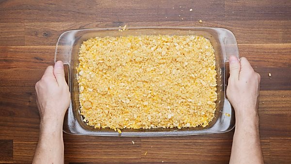 crushed crackers in baking dish over chicken and cheese mixture