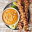 chicken satay skewers on plate with bowl of thai peanut sauce above