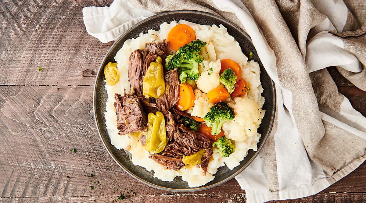 mississippi roast on plate with potatoes and veggies above