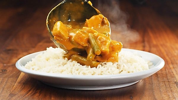 red curry being served over rice