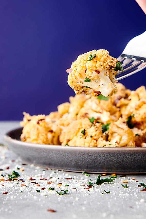 roasted cauliflower on fork, plate in background