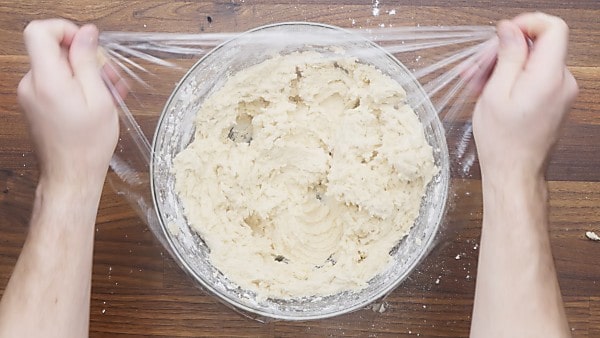 snickerdoodle cookie dough in bowl covered with plastic wrap