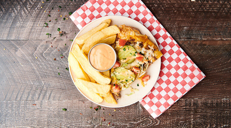slice of cheeseburger pizza on plate with fries and fry sauce