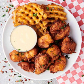 popcorn chicken with waffle fries and ranch on plate above