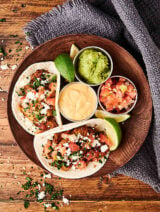 pork tacos on plate with sauces above