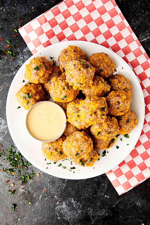 sausage balls on plate with dipping sauce above