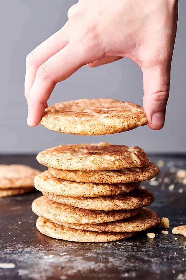 snickerdoodle cookies stacked, one being lifted