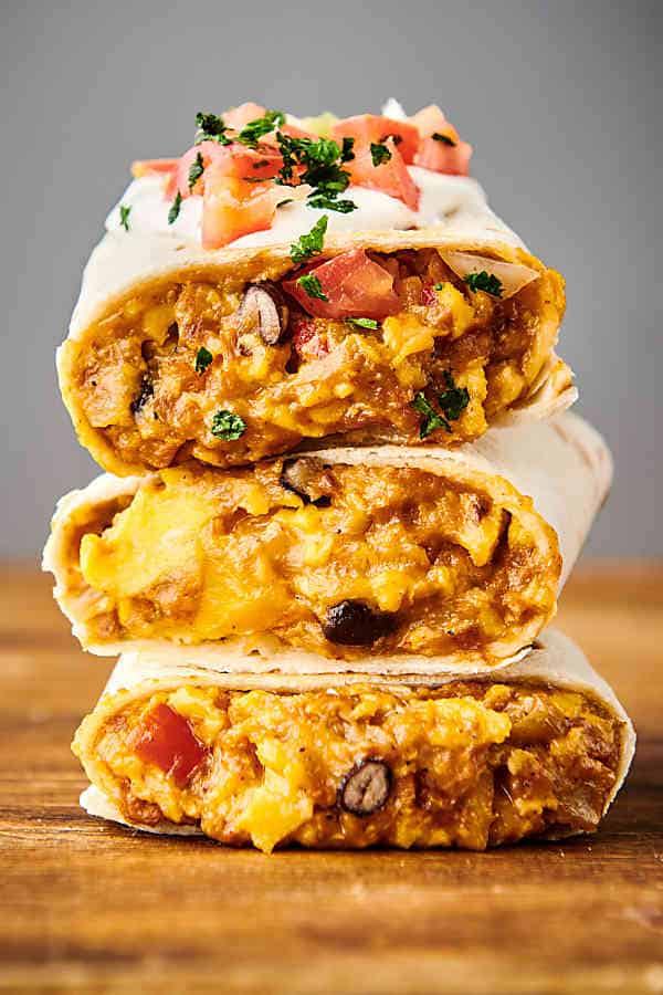 three vegetarian breakfast burritos stacked