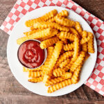 plate of air fryer frozen french fries on plate with ketchup above