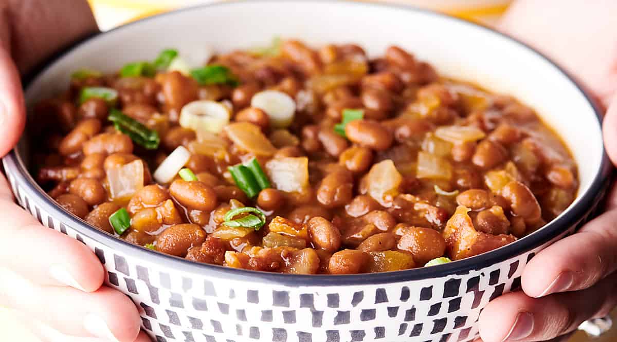 bowl of bbq baked beans held two hands