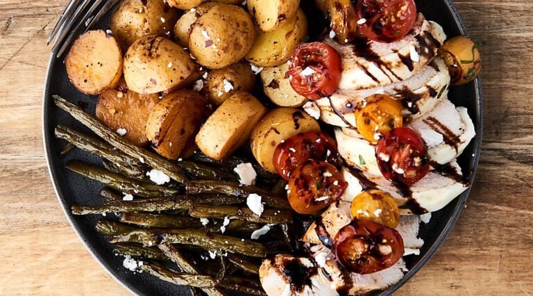 bruschetta chicken on plate with potatoes and green beans above