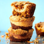 three carrot cake muffins with cream cheese filling stacked