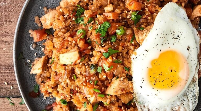 chicken cauliflower fried rice on plate with fried egg above