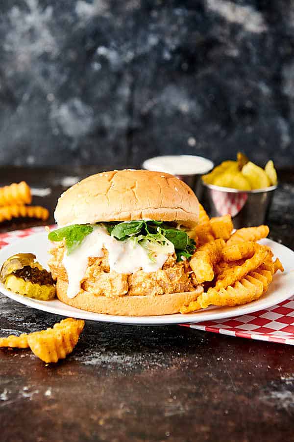 buffalo chicken sandwich on plate with fries