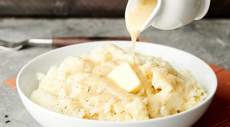 gravy being poured over mashed potatoes