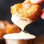 monkey bread being dipped into frosting