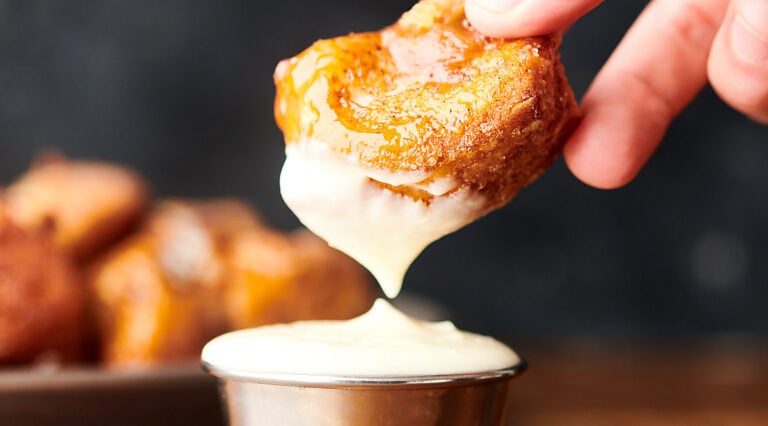 monkey bread being dipped into frosting