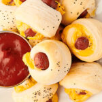 pigs in a blanket on plate with ketchup above