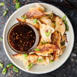 plate of potstickers with sauce above