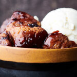 bowl of slow cooker cherry cobbler with scoop of ice cream