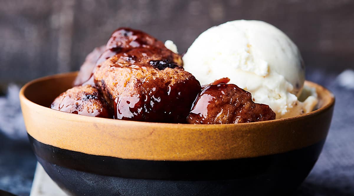 bowl of slow cooker cherry cobbler with scoop of ice cream