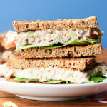 two halves tuna salad sandwich stacked on plate