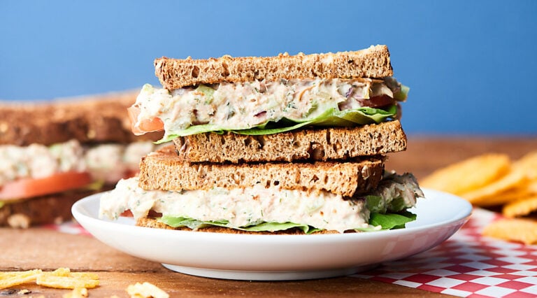 two halves tuna salad sandwich stacked on plate