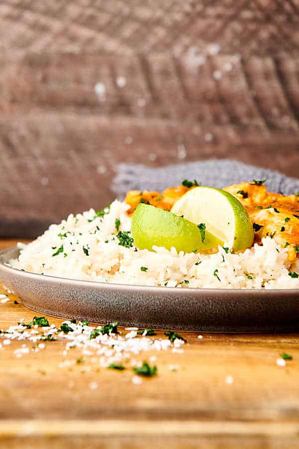 plate of coconut lime rice with chicken and lime slices