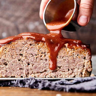 slice of air fryer meatloaf being drizzled with sauce