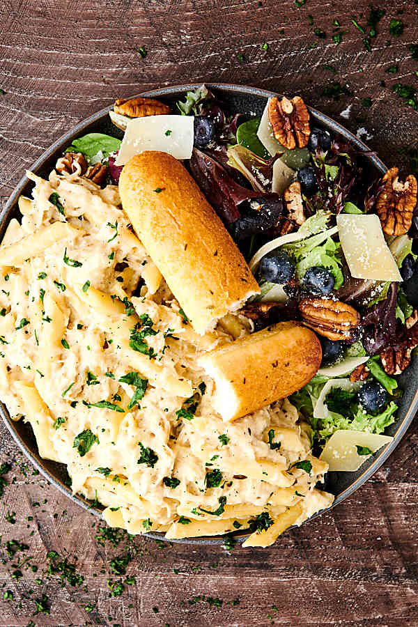 plate of crockpot chicken alfredo with salad above
