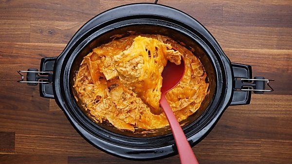 slow cooker chicken enchiladas being served with ladle