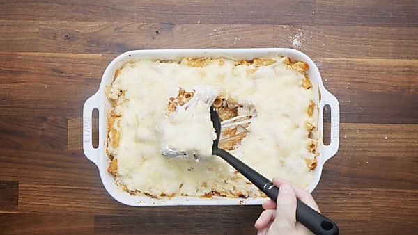 baked rigatoni being scooped with ladle