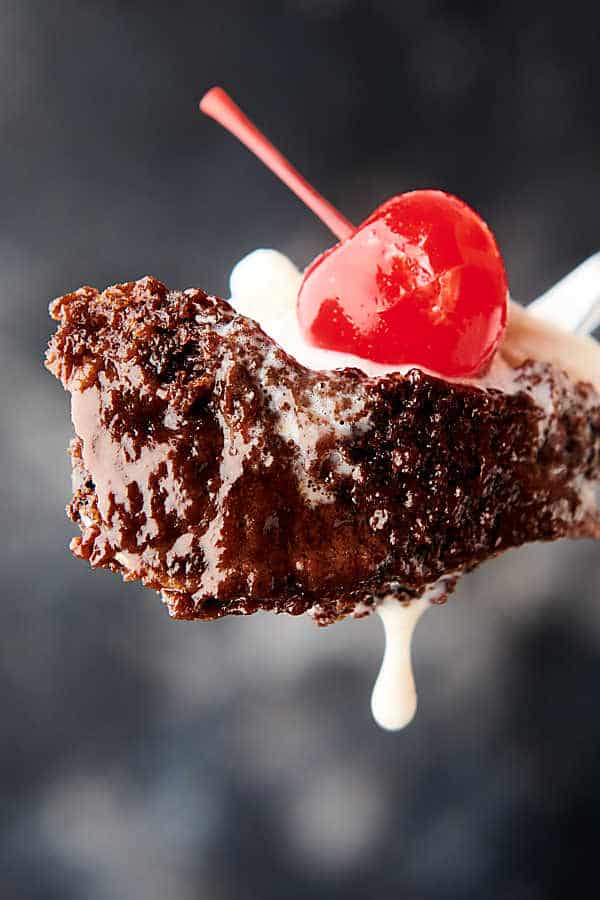 bite of chocolate cake on fork with cherry